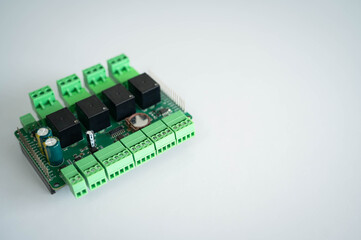 Industrial relay controller board isolated on a white background with copy space, featuring terminal block connectors for IoT, industrial automation, embedded systems, electronics engineering. © Narong