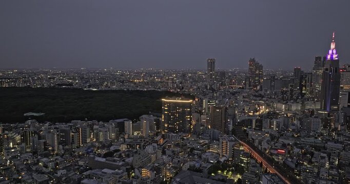 Tokyo Japan Aerial v177 cinematic drone flyover Sendagaya capturing Yoyogi park and illuminated Shinjuku city downtown cityscape at dusk night - Shot with Mavic 3 Pro Cine - October 2023