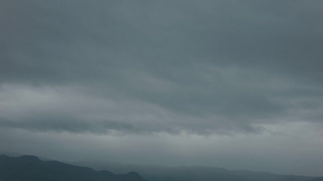 Silhouette of distant mountain ranges and gray clouds