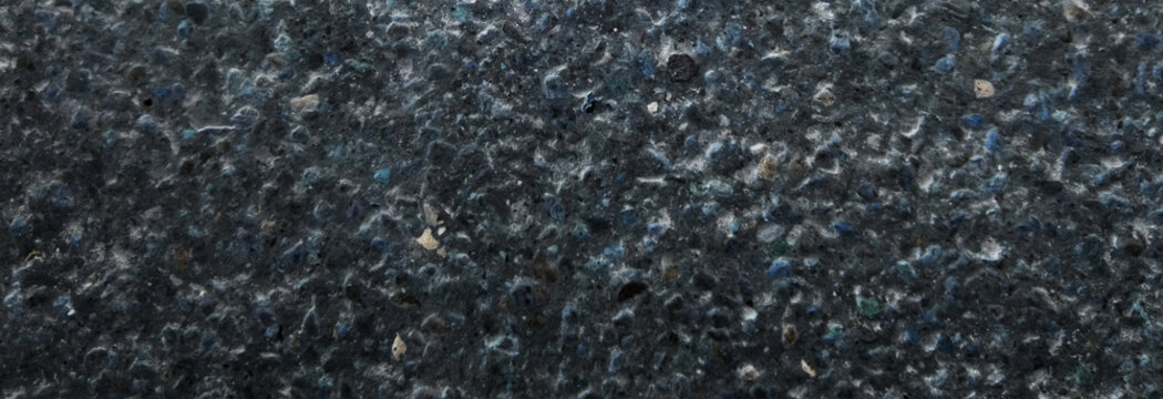Black asphalt texture background, dark grainy road surface close up, rough bitumen pavement material, industrial charcoal stone backdrop