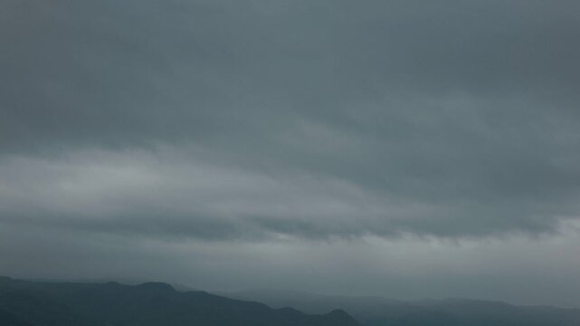 Silhouette of distant mountain ranges and gray clouds