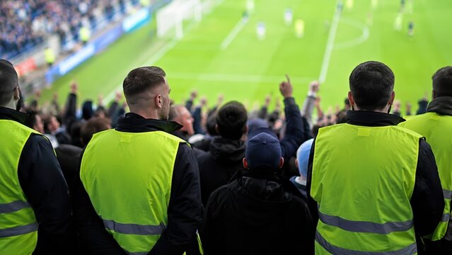 Security Guards Watching a Professional Soccer Match in a Stadium