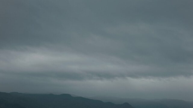 Silhouette of distant mountain ranges and gray clouds