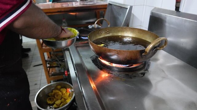 Chef Frying Indian Pakora in Hot Oil Wok at Street Food Kitchen