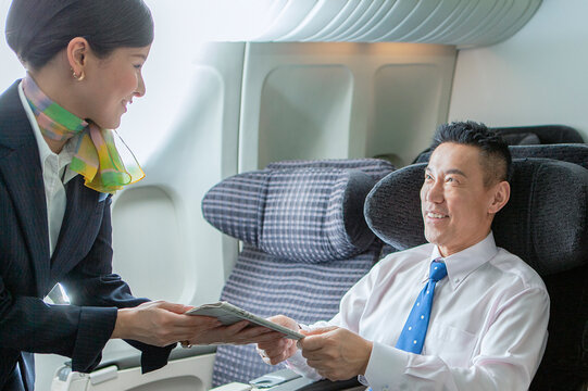 機内でCAと話すビジネスマン