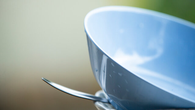 Macro shot of a light blue ceramic bowl with fresh water droplets.