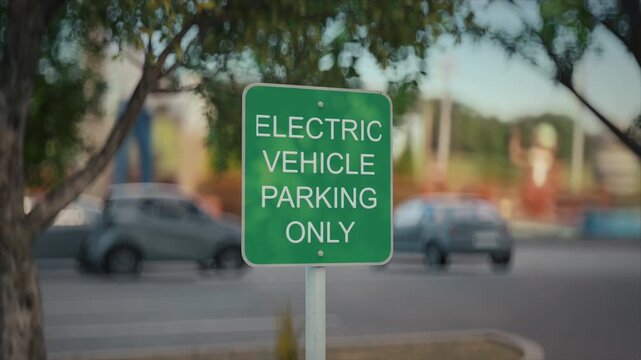 Close-up of a green Electric Vehicle Parking Only sign beside a city street. 3D Render Animation