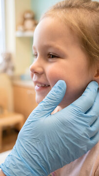 Pediatrician Palpating Child Cheek for Parotitis or Lymphadenitis