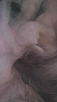 Vertical video. Sparkling background. Abstract paint. Defocused pink color ink in chemical water glitter wet smoke splash pigment on art.