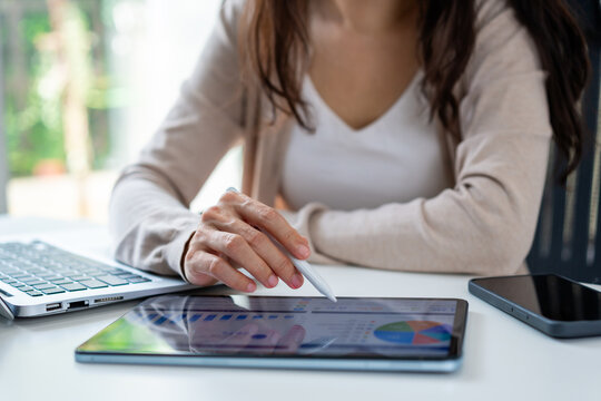 Data analysis and business planning concept: Entrepreneur monitoring financial statistics and reports using digital devices