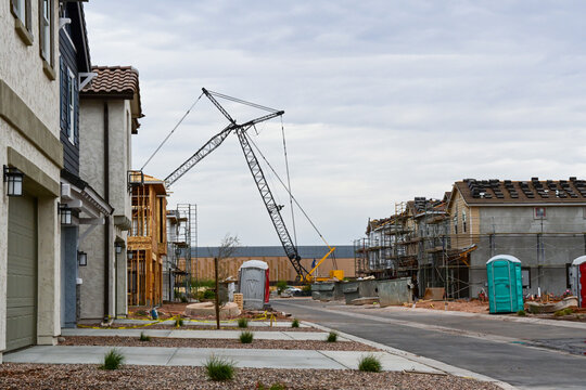 Residential development under construction across from a data center construction site with tower crane, illustrating housing growth, digital infrastructure, and expanding urban development