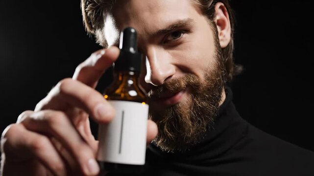 Man with Beard Holding Beard Oil Bottle.