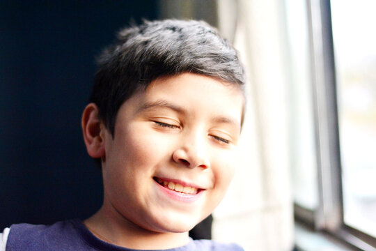 Laughing boy with closed eyes.