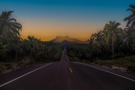 The view along the paved road offers a foreground of the high peaks of Khao Phanom Bencha National Park in Krabi Province, Thailand.