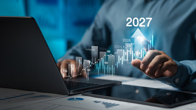 Businessman analyzing financial growth chart for 2027 Stock market finance and profit growth concept with increasing financial trend on revenue graph.