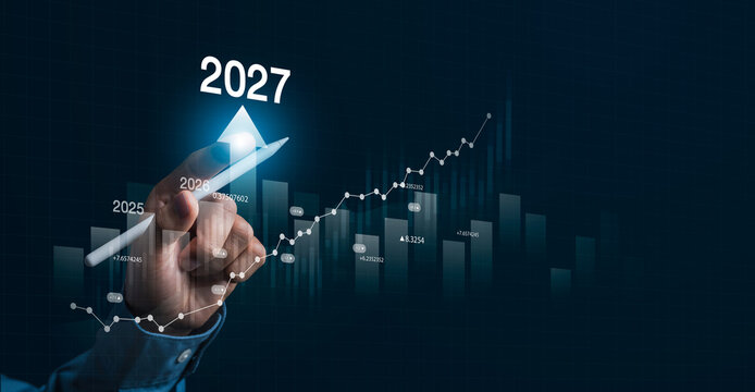 Businessman analyzing financial growth chart for 2027 Stock market finance and profit growth concept with increasing financial trend on revenue graph.