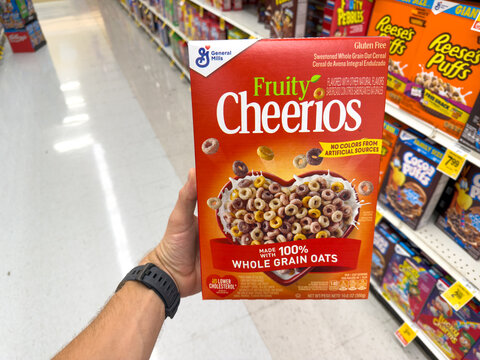 Fruity Cheerios Cereal Box Held In Grocery Aisle