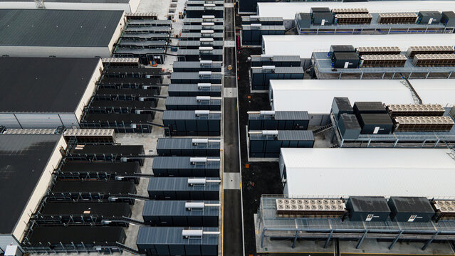 Aerial view of a large data center facility featuring rows of server containers and industrial cooling systems in Keflavik, Reykjanesbaer, Iceland.