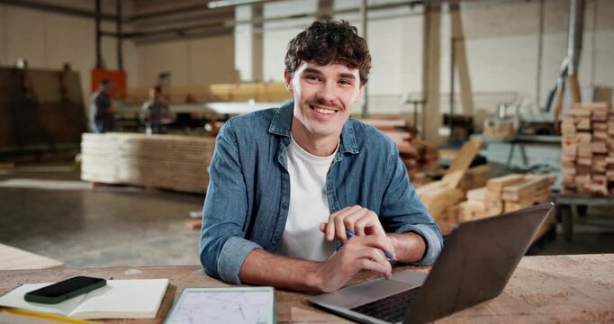 Face, carpenter and laptop with man in workshop for contractor, woodworking update and project. Manufacturing, artisan and furniture supply chain with person in factory for inventory report