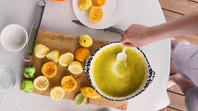 A person is mixing ingredients in a bowl with a spoon on a kitchen countertop, viewed from a top-down perspective. The scene is focused and concentrated, emphasizing the healthy lifestyle.