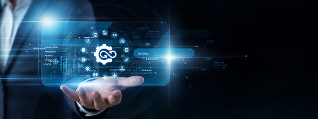 Cloud engineer utilizes a handheld pad to interact with a virtual screen monitoring continuous DevOps pipelines. Automated code deployment and software infrastructure updates are streamlined. © NexPix