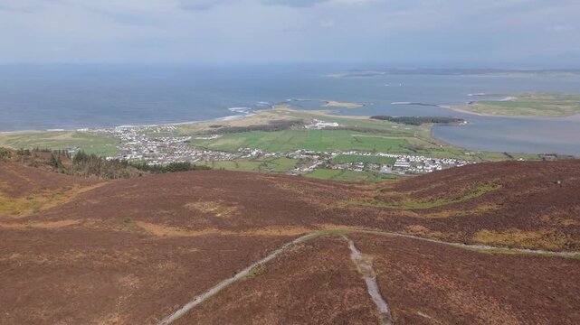 The Coastal Village Of Strandhill From The Slopes Of Knocknarea Mountain In County Sligo, Ireland. Aerial Reveal Shot