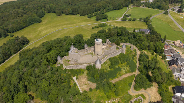Aerial view of Nurburg Castle surrounded by lush green forests and rolling hills in Nurburg, Rhineland-Palatinate, Germany.