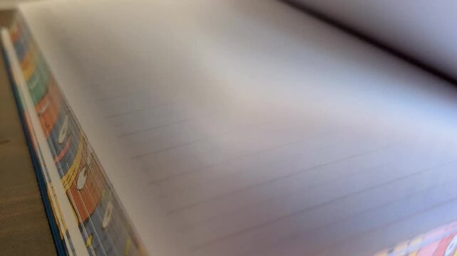 Fast flipping through blank lined pages of a children's diary or notebook for creative writing, reading, and learning concepts, showcasing the passage of time and knowledge