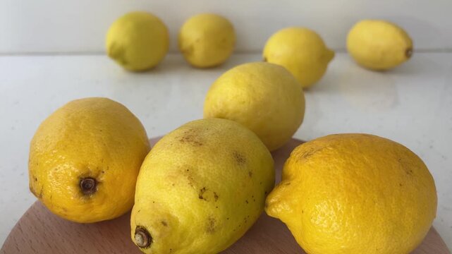 Fresh ripe yellow lemons on a cutting board showcasing natural vitamin c rich citrus fruit for healthy eating, cooking, and organic food concepts with a white background
