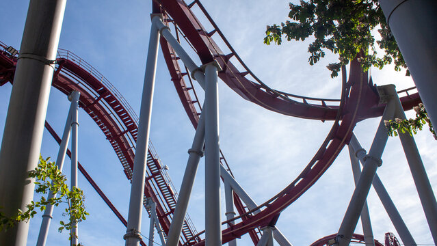 Rollercoaster track viewed from below, against a blue sky