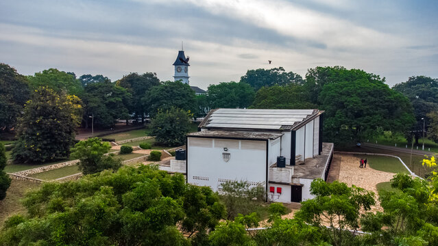 Aerial view of Achimota School campus featuring a clock tower and a building with solar panels, surrounded by lush trees and greenery in Achimota, Greater Accra Region, Ghana.