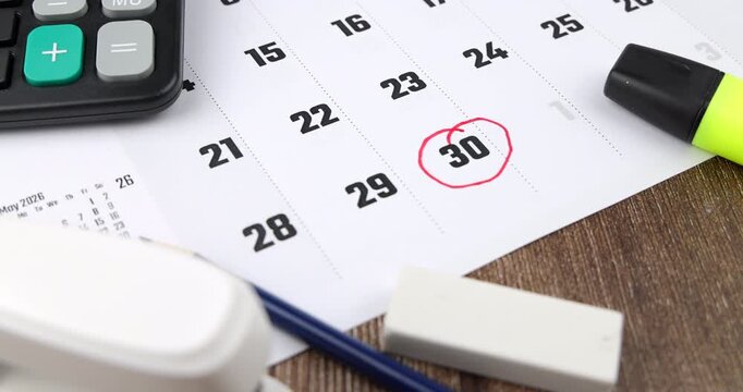 Beautiful horizontal camera movement over a brown wooden desk workspace with business calendar and office calculation stationery