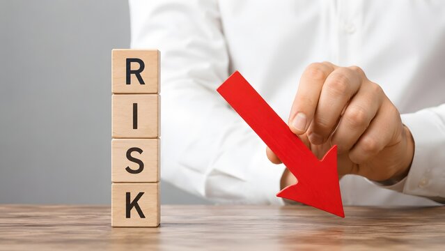Decreasing business risk and economic decline concept with hand lowering a red downward trend arrow