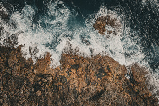 Aerial view of Conspicuous Cliff with powerful ocean waves crashing against rugged rocky coastline in Nornalup, Western Australia, Australia.