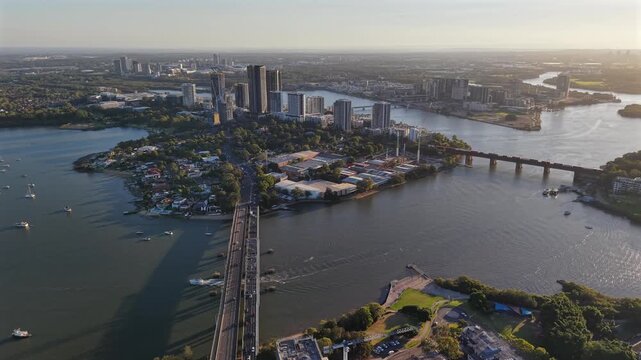Aerial drone video panning left over Rhodes in Sydney, showcasing waterfront apartments, Parramatta River views, urban parkland, and modern residential development in Australia