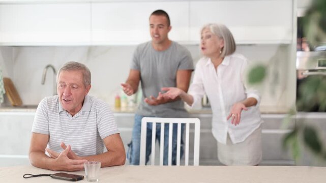 Adult man sits at table and thinks how to resolve conflict with his wife and son . High quality 4k footage