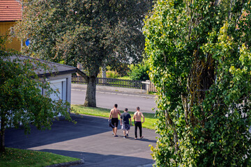 Naklejka premium Group of young men walking on a street on a summer day