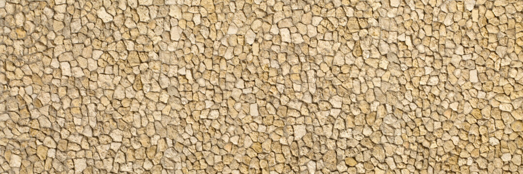 Rough beige rock wall creating textured background pattern