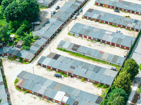 Aerial view of rows of garages in the Zemgale Suburb with paved access paths and parked cars in Riga, Latvia.