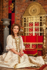 Fototapeta premium Elegant Woman in Vintage Attire Poses Gracefully in a Richly Decorated Outdoor Setting