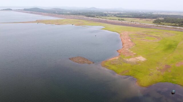 Mukutmanipur Dam In Bankura District West Bengal Aerial view of scenic lake with green shores and long dam in countryside under overcast sky.