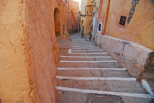Algeria, Ben Isguen, run-down mud brick wall with an arched way and staircase