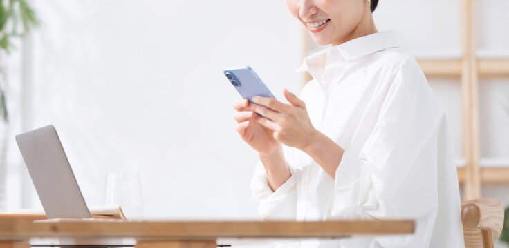 スマートフォンとノートパソコンを使う女性