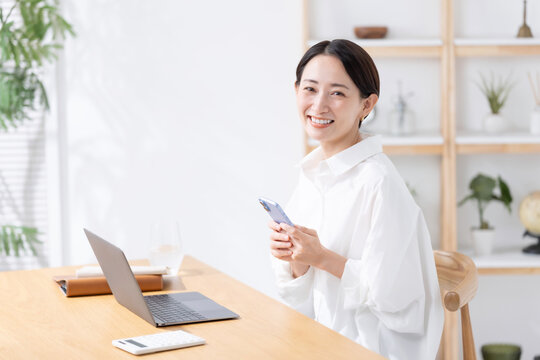 スマートフォンとノートパソコンを使う女性