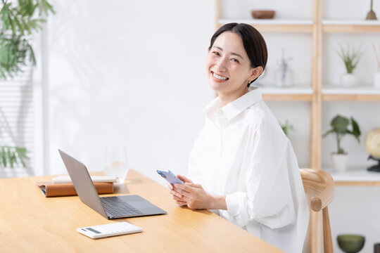 スマートフォンとノートパソコンを使う女性