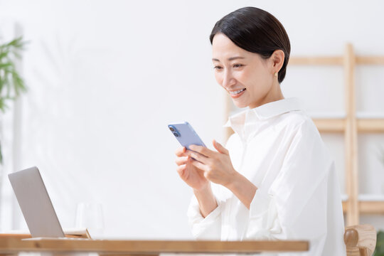 スマートフォンとノートパソコンを使う女性