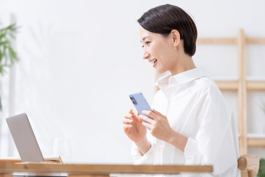 スマートフォンとノートパソコンを使う女性