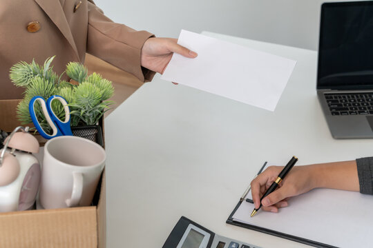 resignation, leave, quit, employee pass on resignation letter to Business owner . staff is lifting a brown paper box that holds personal items. , job placement and vacancies, resignation letter
