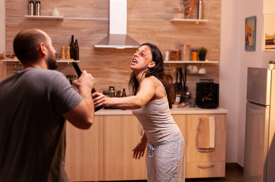 Abused wife resisting violent husband presents domestic violence, emotional trauma and personal safety in an unsafe home relationship.