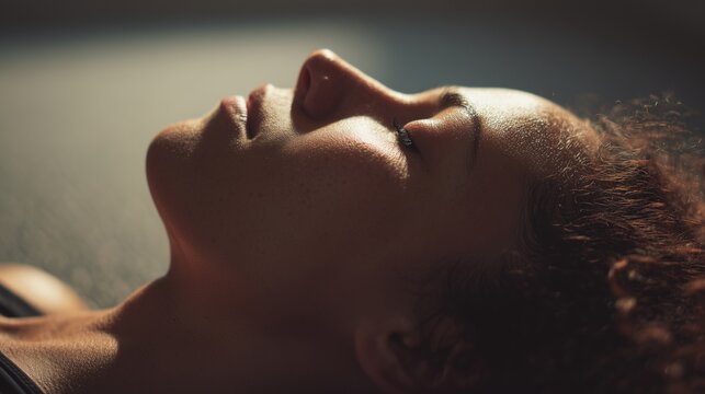 Closeup of a woman resting with eyes closed, symbolizing somatic therapy, body awareness, calm breath, and inner healing.